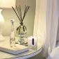 PAIRFUM luxury scented candle, natural reed diffuser and couture perfume room spray on the bedside table in a sixties style bedroom