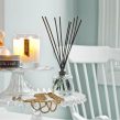 PAIRFUM luxury scented candle and natural reed diffuser on a side table in a French cottage