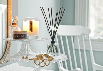 PAIRFUM luxury scented candle and natural reed diffuser on a side table in a Nordic style house