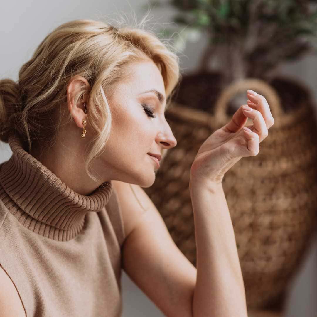 Where to Spray Perfume: Master the Art of Fragrance Application. fragrance layering; a woman smelling her wrist